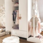 Open wardrobe in the children's room in white.