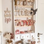 White louve shelf in a girl's room, colourful hair bands are hung on the shelf